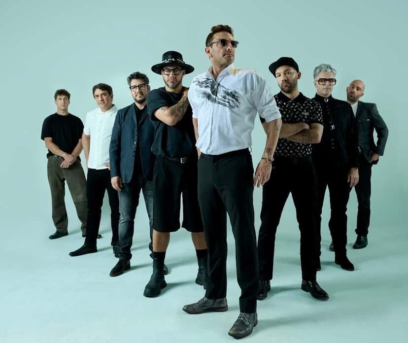 Foto de prensa de No Te Va Gustar difundida con el anuncio de los shows: los ocho integrantes de pie sobre un fondo verde agua, uno adelante con camisa blanca y anteojos oscuros