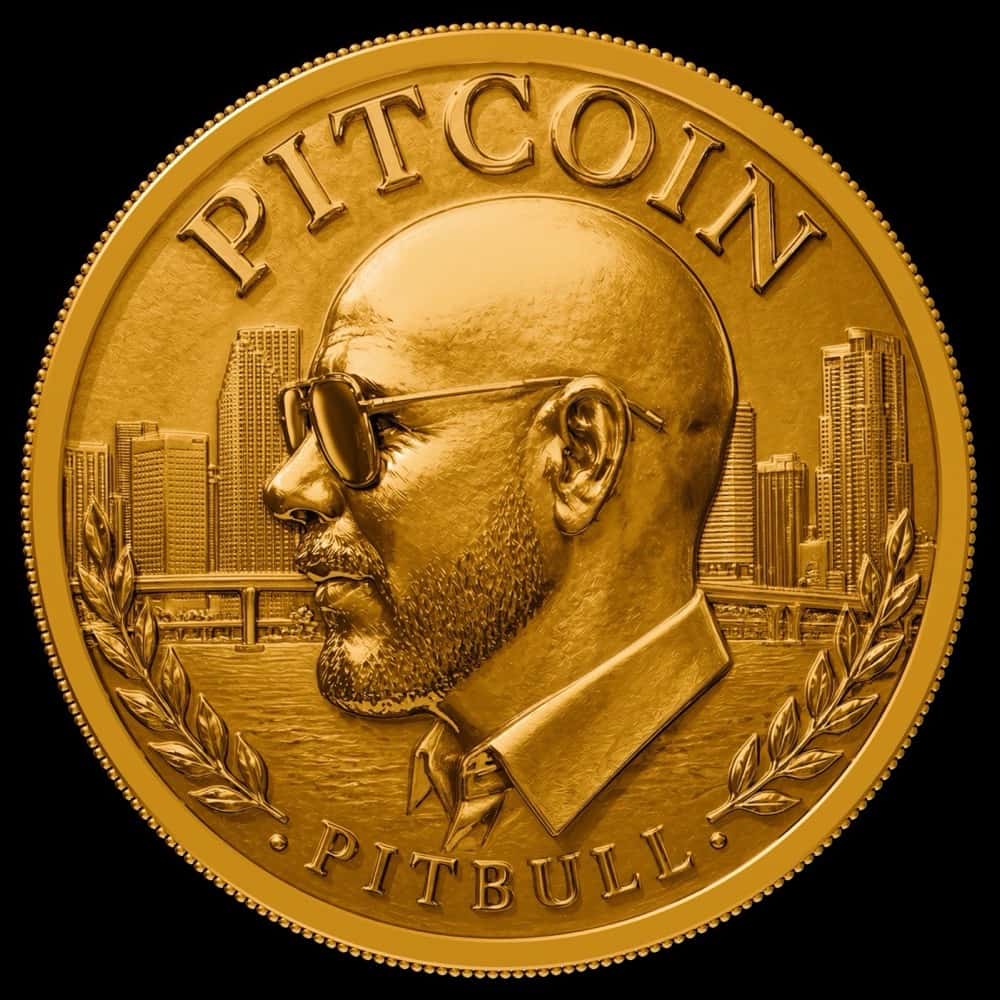 Portada de «PITCOIN», de Pitbull: una moneda dorada con el perfil del cantante, de anteojos de sol, frente a edificios de Miami y palmeras