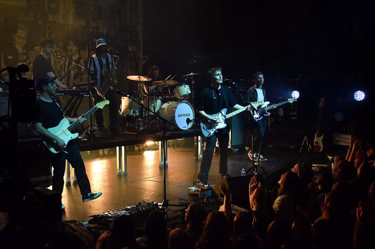 Sam Fender toca la guitarra y canta con su banda en un escenario de París en 2020, frente al público con las manos en alto (foto de archivo)