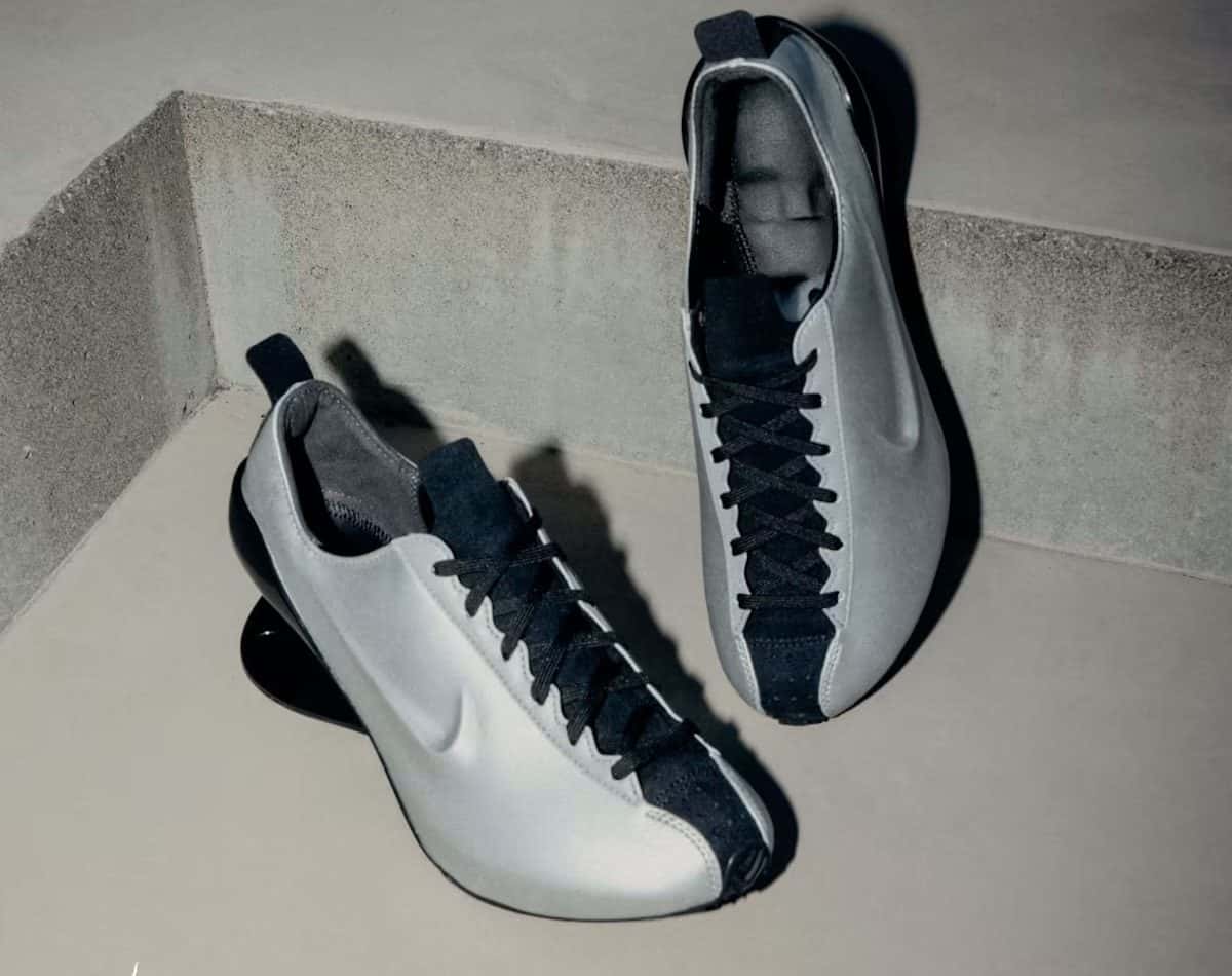 Par de Nike Ovolo 2.0 en plateado metalizado con cordones negros, apoyado sobre un escalón de cemento, con el taco negro brillante a la vista