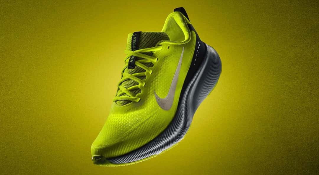Nike Vegam Run en verde lima con la pipa plateada y la suela gris oscura, sobre un fondo amarillo