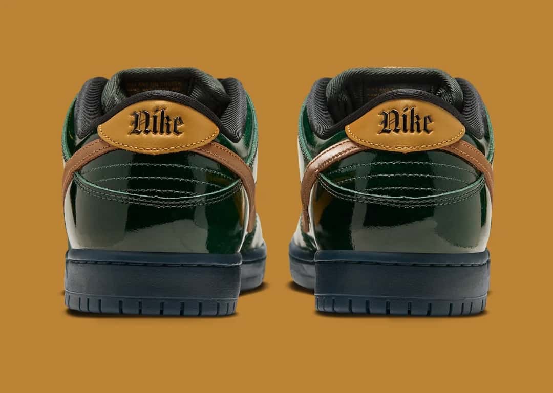 Talones de la Nike SB Dunk Low Champagne con la palabra Nike en letra gótica sobre el refuerzo dorado
