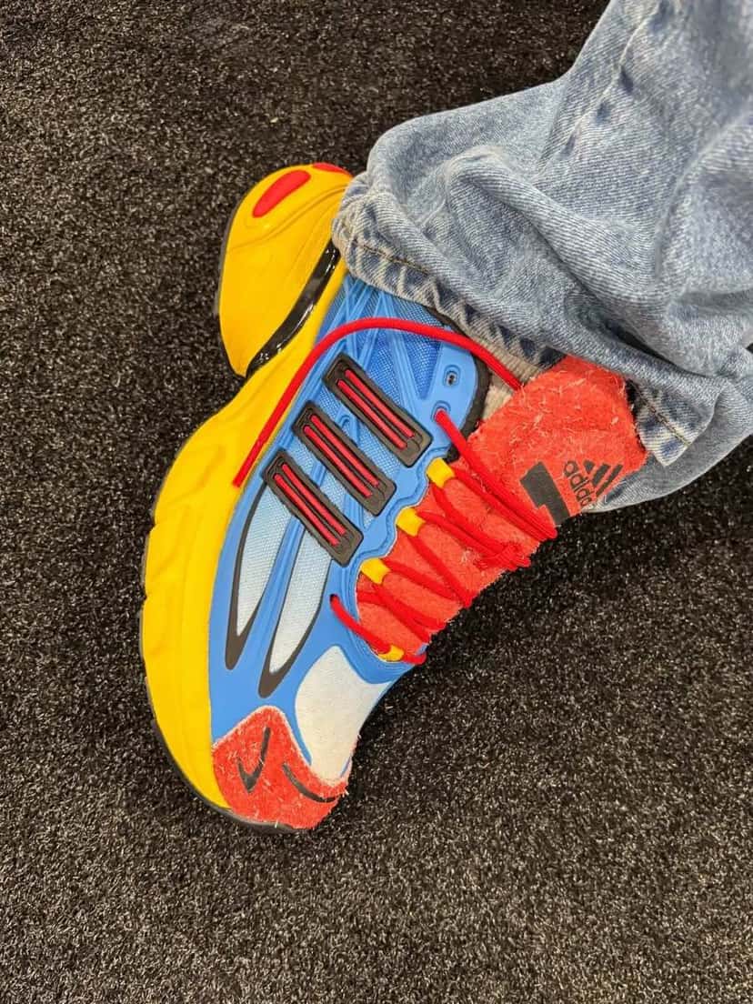 adidas Adistar XLG 2.0 Mandrill de Shake James vista desde arriba, con malla azul, tres tiras negras con detalle rojo, cordones rojos y gamuza roja en la lengüeta y la puntera