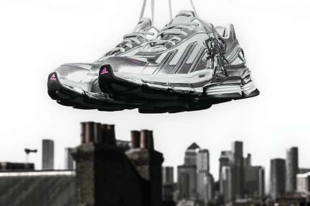 SP5DER x adidas F50 Formotion KZ6575 en Silver Metallic colgado de los cordones sobre un paisaje urbano