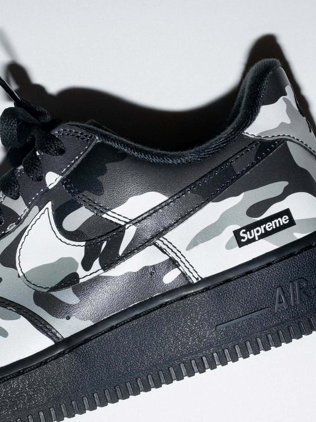 Detalle del talón de la Supreme x Nike Air Force 1 Low Snow Camo, con el box logo de Supreme sobre el camuflaje y la entresuela negra