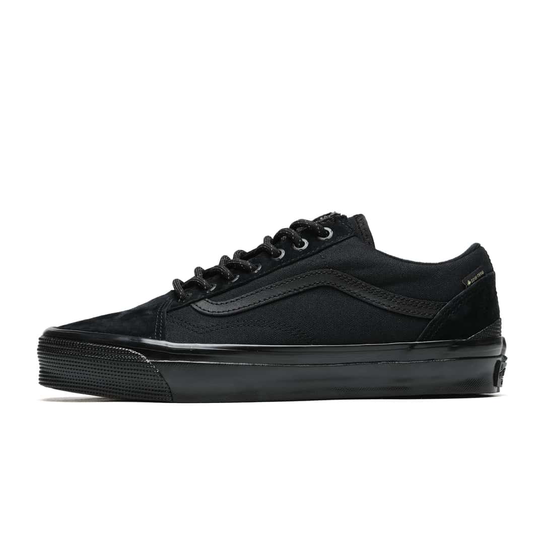 Vans Premium Old Skool GORE-TEX Black de perfil sobre fondo blanco, todo negro: gamuza en la punta y el talón, paneles de lona, Sidestripe de cuero negro, etiqueta GORE-TEX en el costado y suela de goma negra